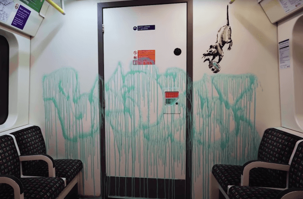 Banksy tags the London Tube with masked-themed graffiti
